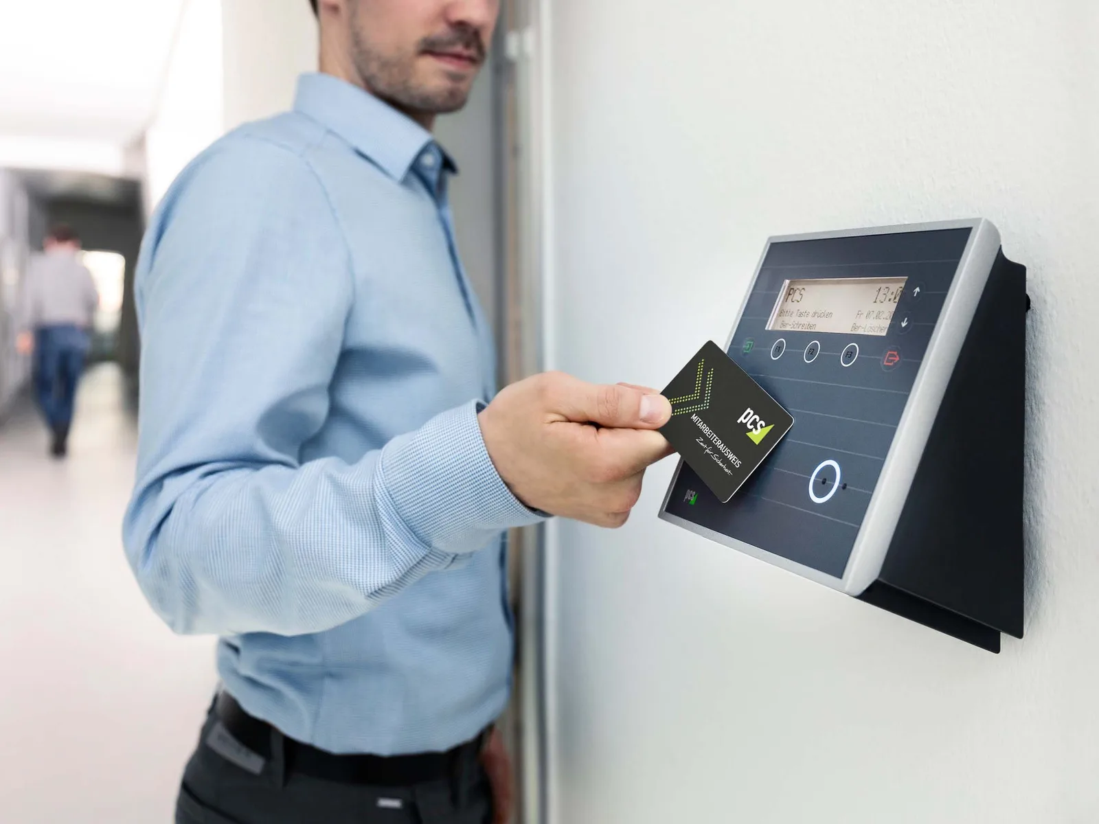 Employee tapping an access card against a wall-mounted card reader