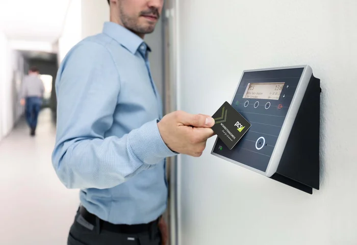 Employee tapping an access card against a wall-mounted card reader