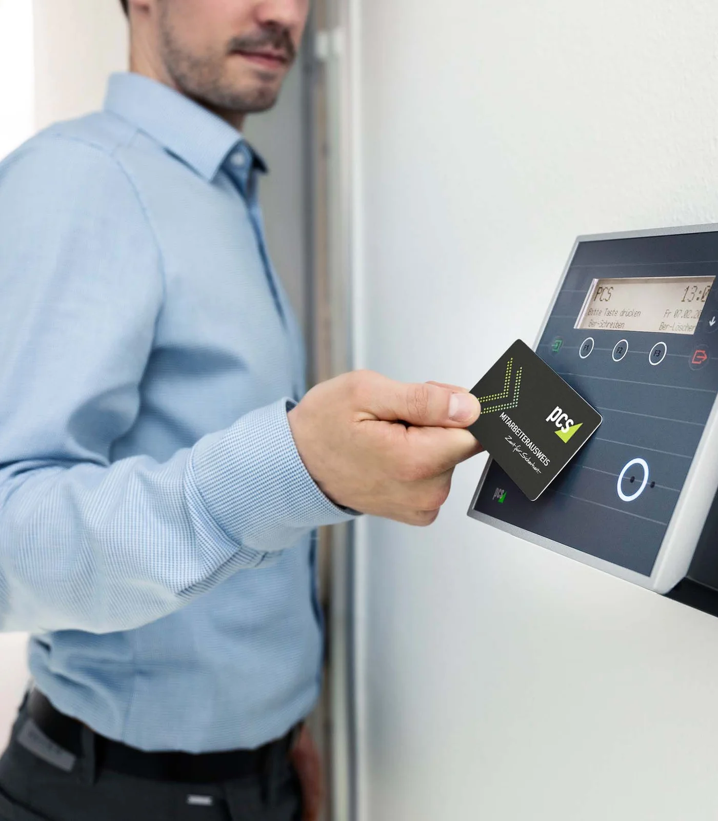 Employee tapping an access card against a wall-mounted card reader