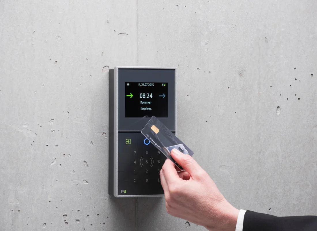 Hand tapping an access card against a wall-mounted keypad terminal